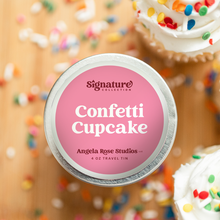 Load image into Gallery viewer, Confetti Cupcake soy candle in a 4 oz travel tin, from the Signature Collection by Angela Rose Studios, shown overhead with cupcakes and sprinkles in the background.