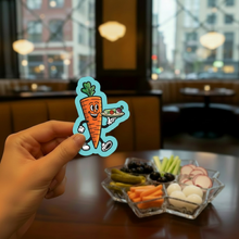 Load image into Gallery viewer, Hand holding a relish tray cartoon character sticker over a relish tray in a supper club dining room.